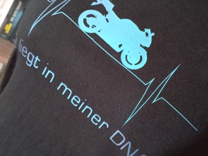 schwarzes Shirt mit dem Print einer Pulslinie mit einem Motorrad und dem Spruch »Es liegt in meiner DNA!«